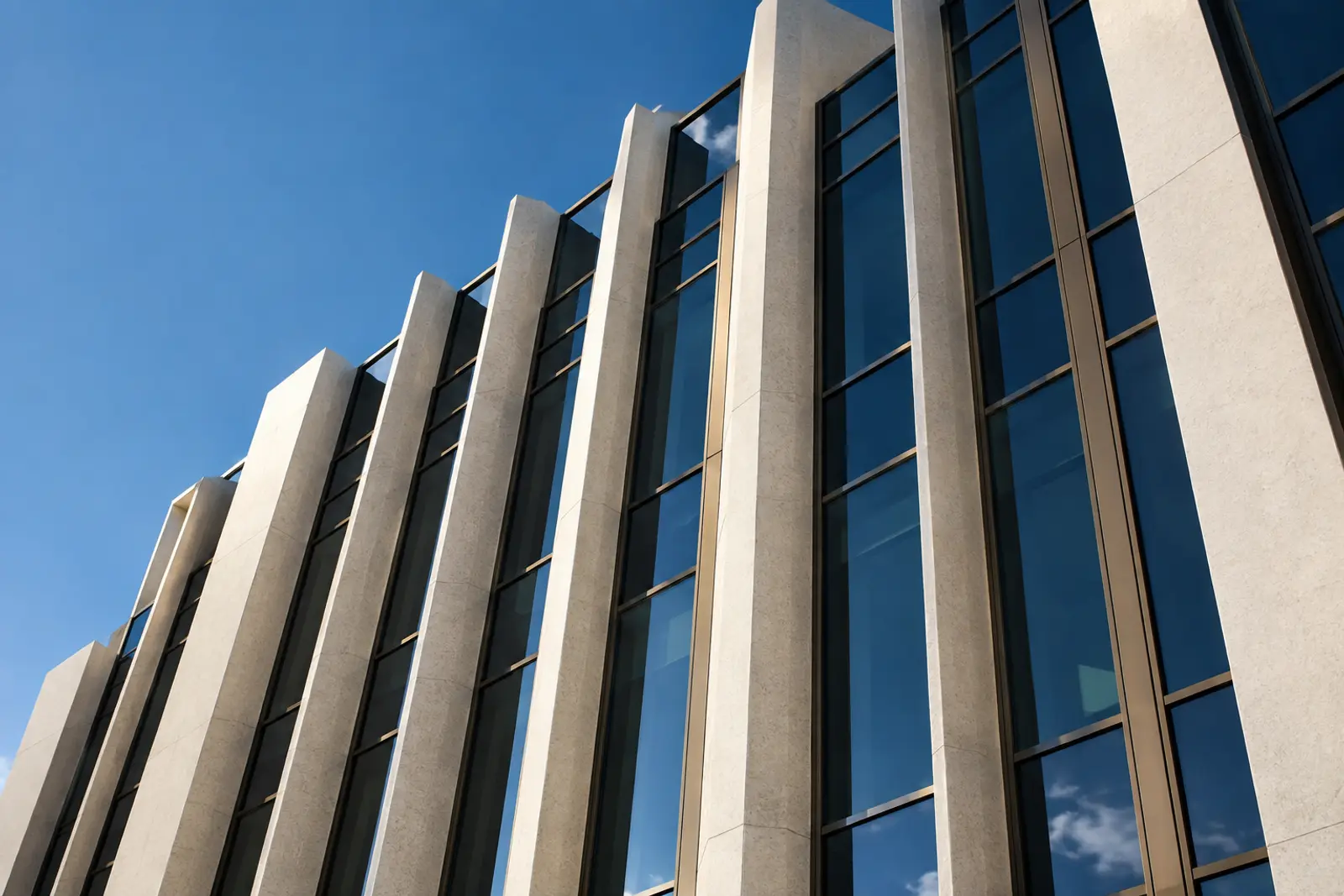 Conceptual commercial facade with concrete fins, bronze framing, and deep blue glass